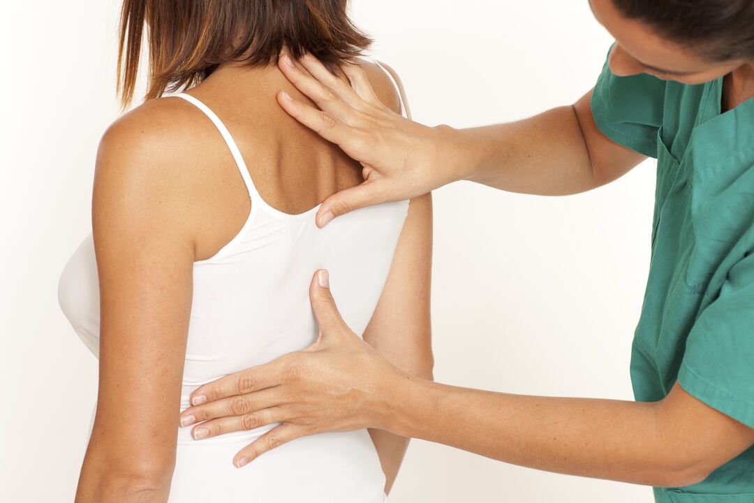 le médecin examine le dos avec l'ostéochondrose thoracique